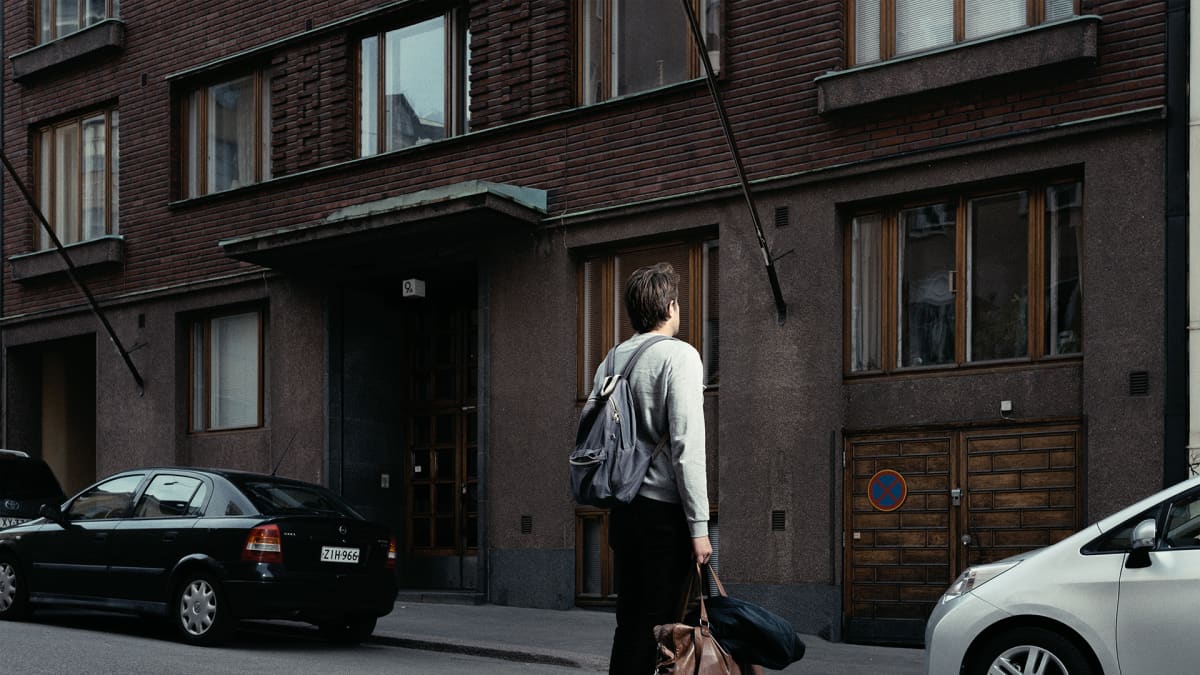 Magnus Bratten seisoo kerrostalon edessä.