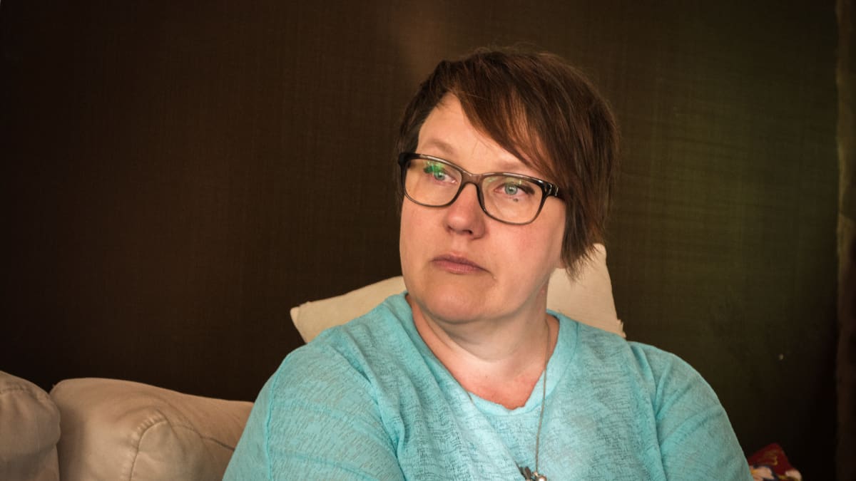 Tiina Piippo istuu kotonaan sohvalla. 