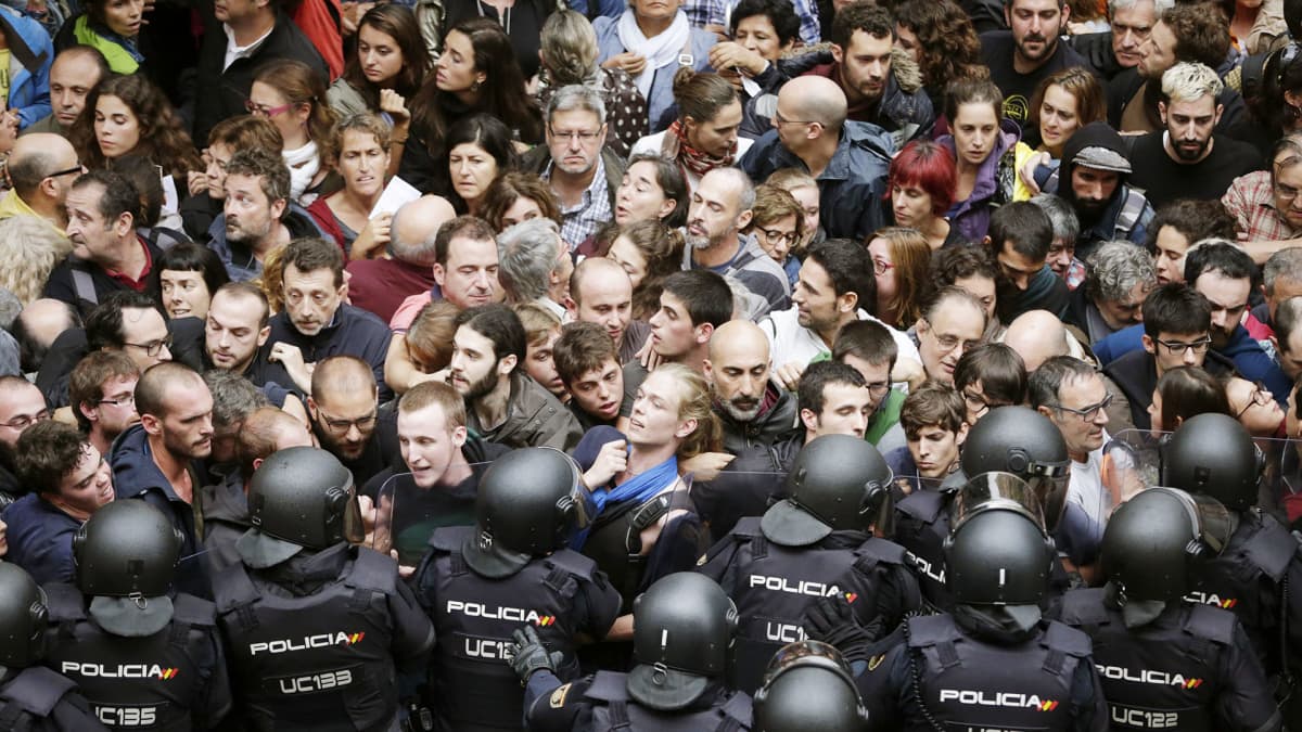 Mellakkapoliisit ja aktivistit ottavat yhteen äänestyspaikkana toimivan koulun edustalla Barcelonassa.