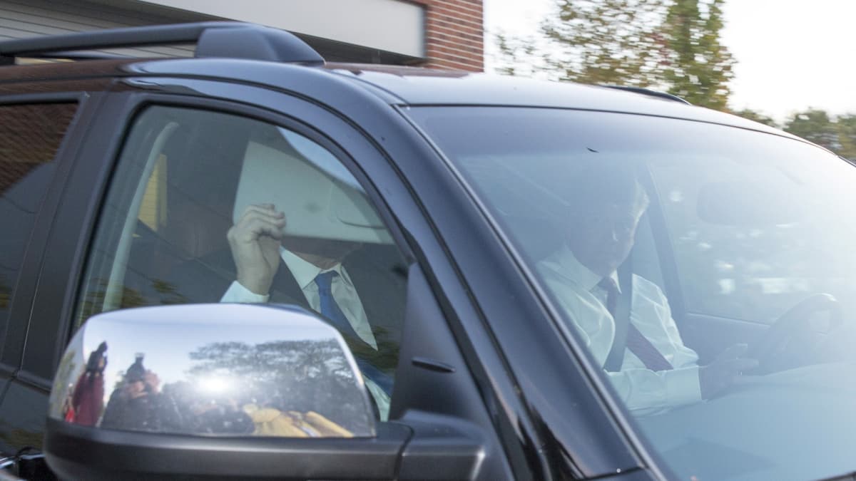 Paul Manafort peittää kasvonsa lähtiessään autolla kotoaan ilmoittautuakseen poliisille.
