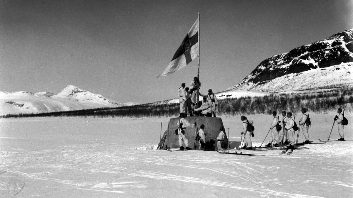 Suomalaissotilaat nostavat lipun kolmen valtakunnan rajapyykille Lapin sodan päätyttyä 27.4.1945