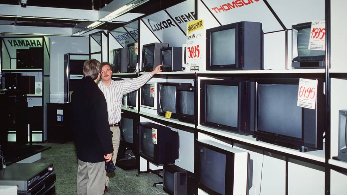 Myyjä esittelee asiakkaalle televisioita myymälässä vuonna 1991.