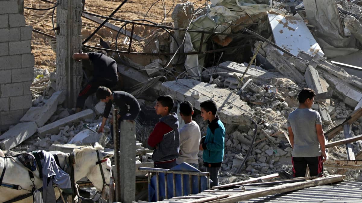 Pojat katselevat tuhotun Hamas-sotilaskohteen raunioita Gazan pohjoisosassa.