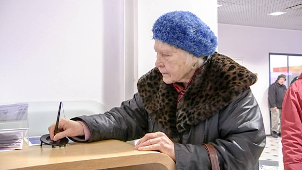 eläkeläinen kirjoittaa pankissa