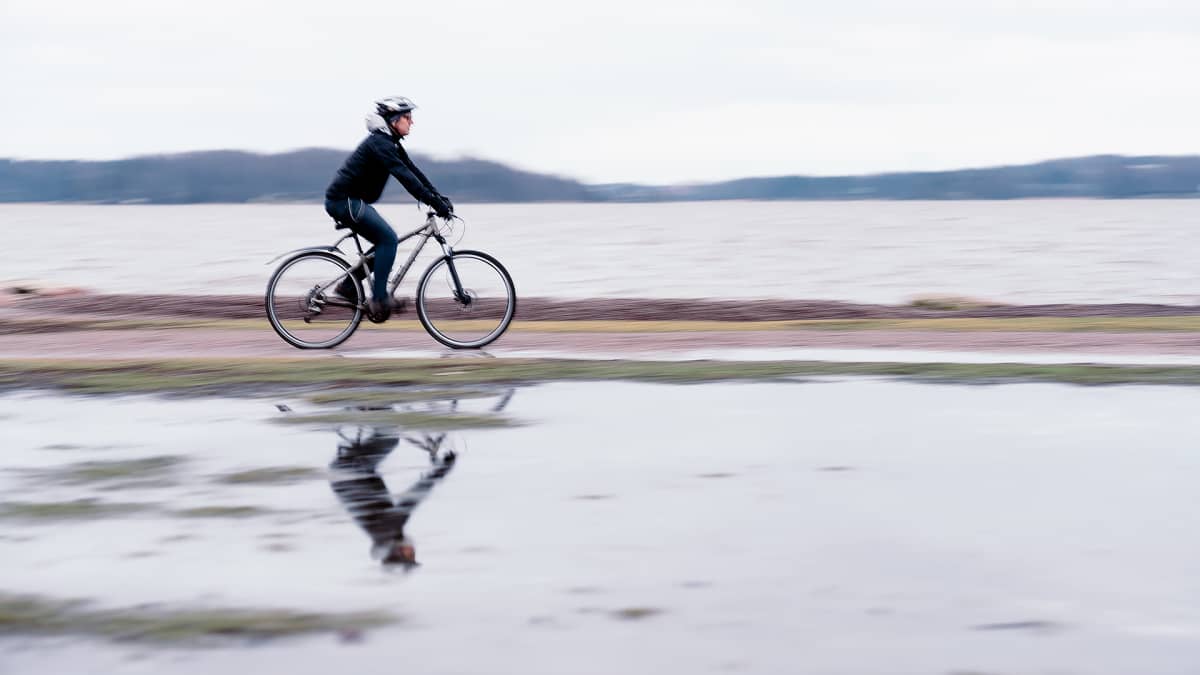 Kirka Sainio pyöräilee rannalla.