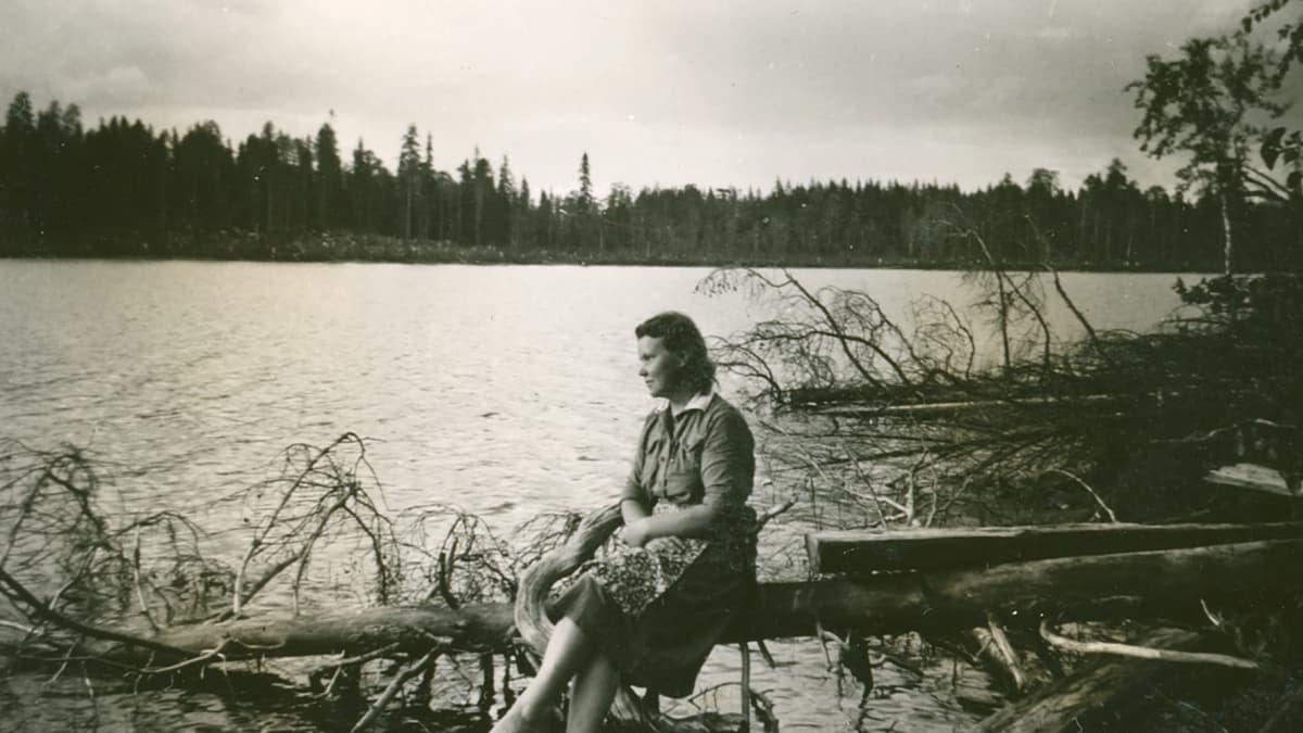 Lotta istuu järven rannalla. 