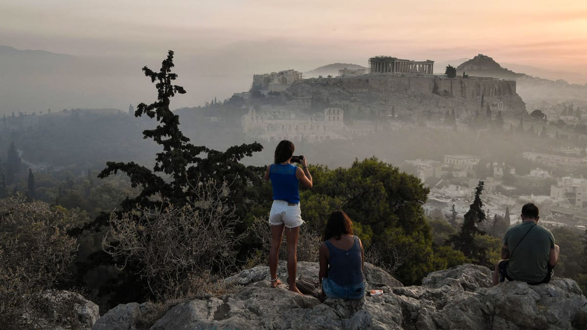 Ihmiset ottavat kuvia Ateenan yllä leijailevasta savusta.