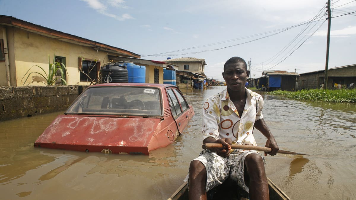 Mies meloo kanootilla tulvaveden peittämällä Ajegunle​n kylän kadulla Lagosin lähistöllä Nigeriassa.