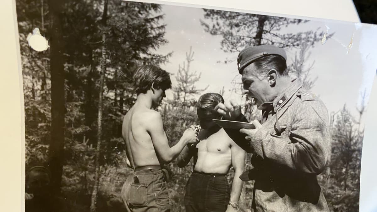 Näyttelijä Tauno Palo ruokailee kuvaustauolla. Taustalla kamera-assistentit Antero Ruuhonen ja Veikko Mård (keskellä) tupakalla. 