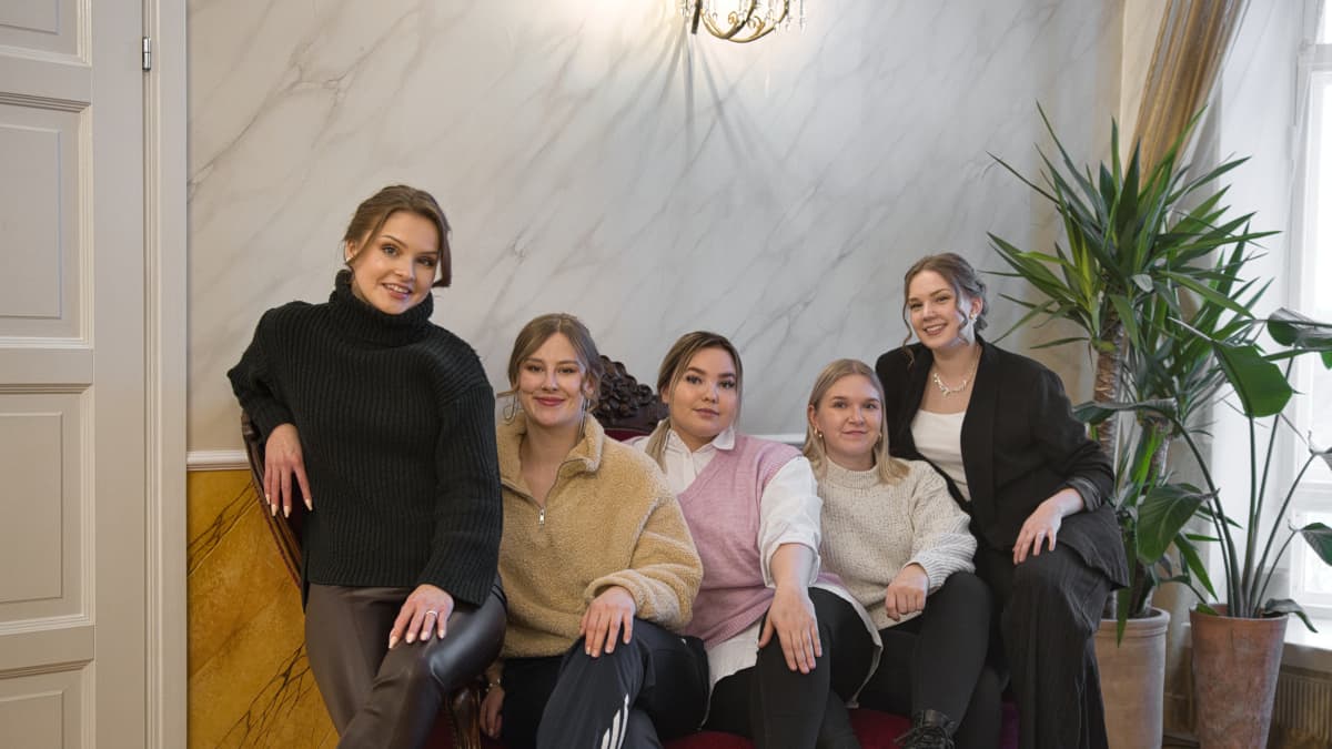 Tiimiakatemnian opiskelijat Iida Leskelä, Beda Räsänen, Emilia Ahonen, Riikka Niemelä ja Laura Autio istuvat sohvalla Kuokkalan Kartanossa.