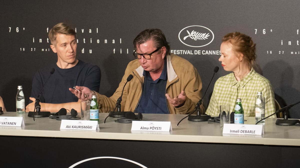 Aki Kaurismäki speaks at a press conference in Cannes. On one side is Jussi Vatanen and on the other side Alma Pöysti.