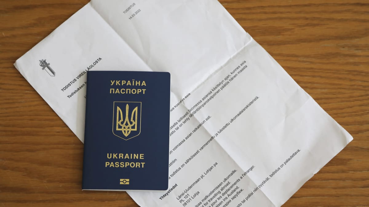 Kuvassa on Ukrainan passi ja poliisin poliisin vireilläolotodistus tilapäisen suojelun hakemuksesta.