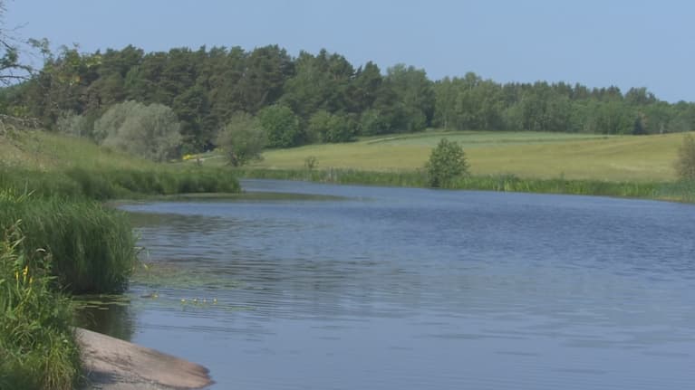 Vatten och åkrar vid sida om den. 