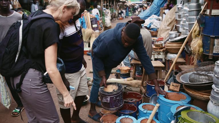  Toimittaja Jessica Stolzmannille esitellään Kampalan aukiolla on myytävänä olevia energiatehokkaita uuneja Afrikassa.