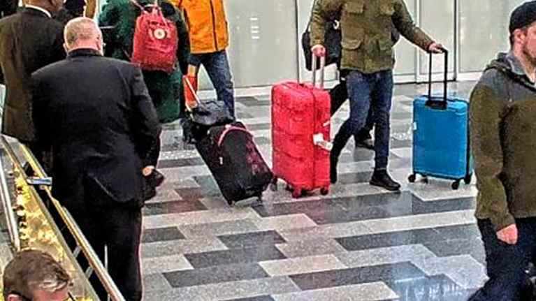 Huumekuriisi työntää värikkäitä laukkuja Helsinki-Vantaan lentokentällä terminaalin käytävällä ihmisjoukossa.