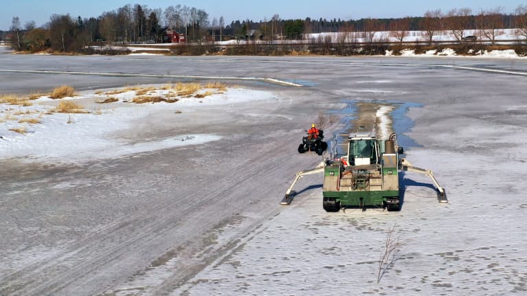 Jäänsahausta Kyrönjoella Isonkyrön Vanhan kirkon lähistöllä 22.3.2022. Jääsahauskone joen jäällä.