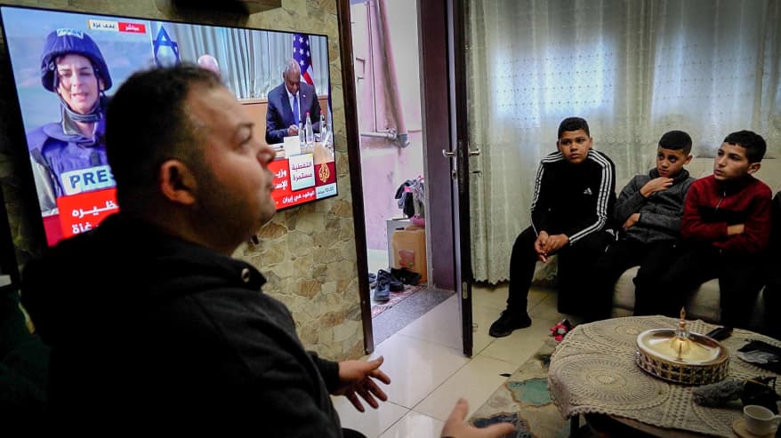Miehiä asunnossa Länsirannalla. Taustalla al-Jazeeran televisio-ohjelmaa.