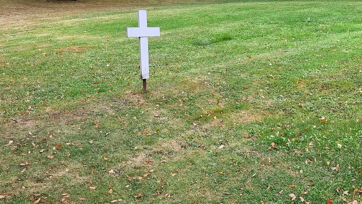 A white cross, the grave of an unknown soldier.