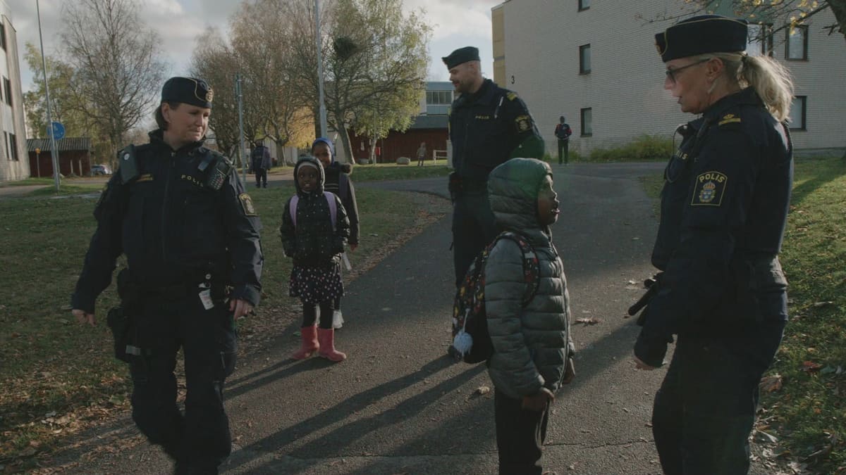 Kaksi aluepoliisia juttelee lasten kanssa Ruotsin Taalainmaalla Bolängen kunnassa.