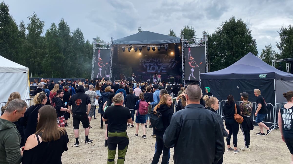 Rock In The City-festivaali Rovaniemellä. Yleisöä ja bändi soittaa lavalla.