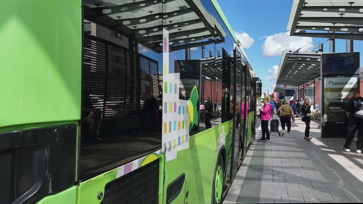 Bussin kylkyljen ikkunat heijastaa jyväskylän bussiterminaalin katoksen. 