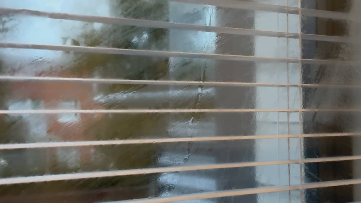 Vesipisara valuu pitkin huurteista ikkunaa. 