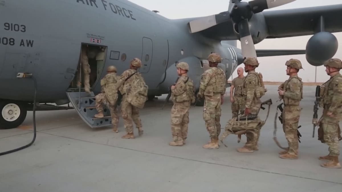 Yhdysvaltain sotilaita jonottamassa harmaaseen lentokoneeseen Irakissa. 