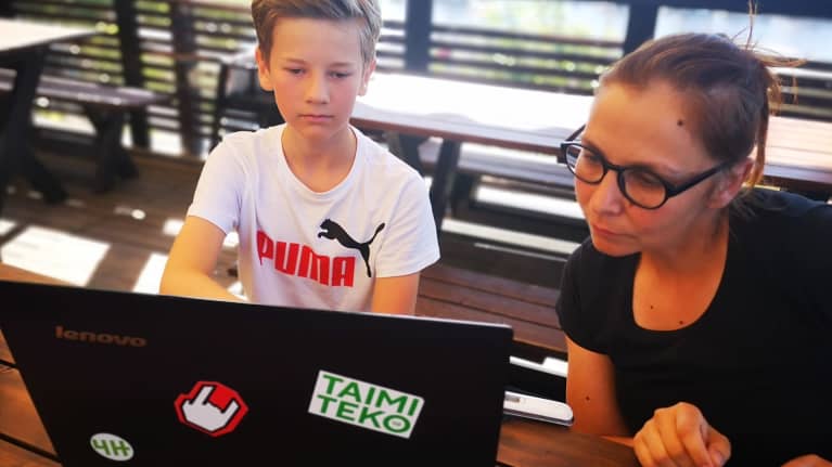 13-vuotias Aatu Mikkonen perustamassa omaa 4H-yritystä. Yrityskurssin vetäjä Ritva Tryyki seuraa vieressä.