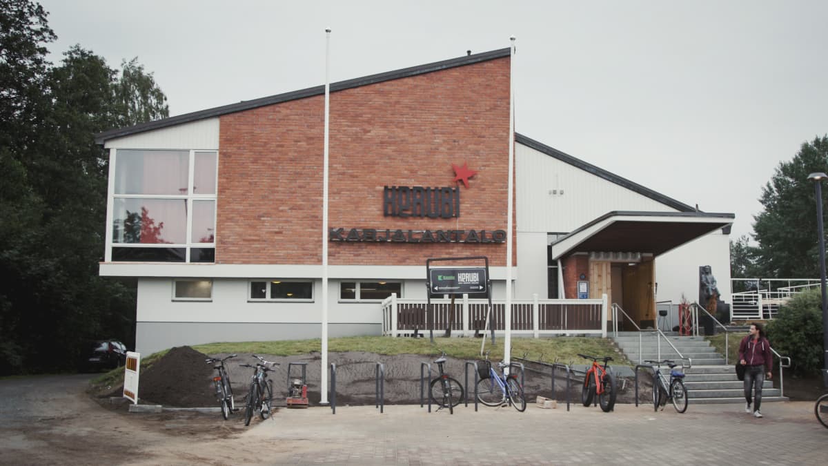 Valkorapattu ja punatiilinen vinokattoinen rakennus, ulkoseinässä teksti "Kerubi Karjalantalo".