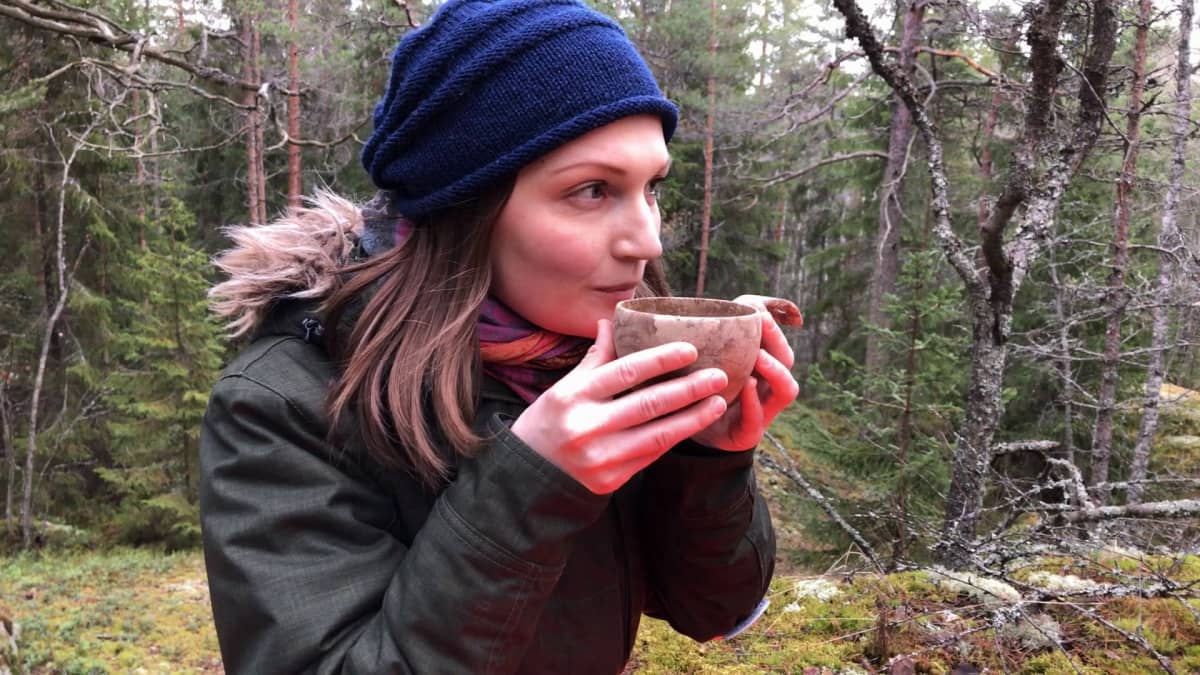 Tutkija Tytti Pasanen juo metsässä teetä kuksasta.