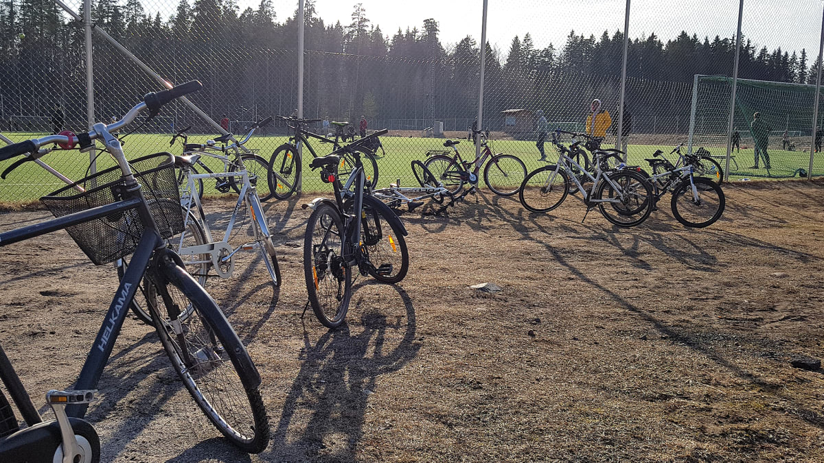 Polkupyöriä palloilukentän laidalla
