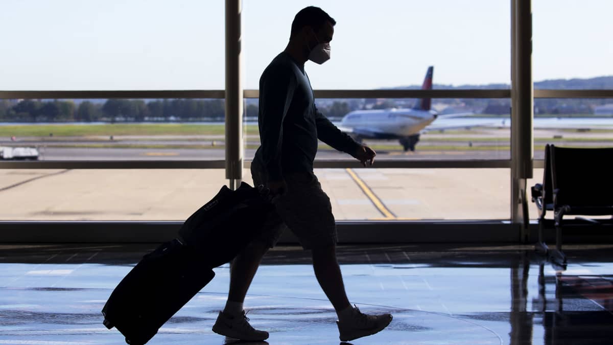 Kasvomasklia käyttävä matkustaja Ronald Reaganin lentoasemalla Arlingtonissa.