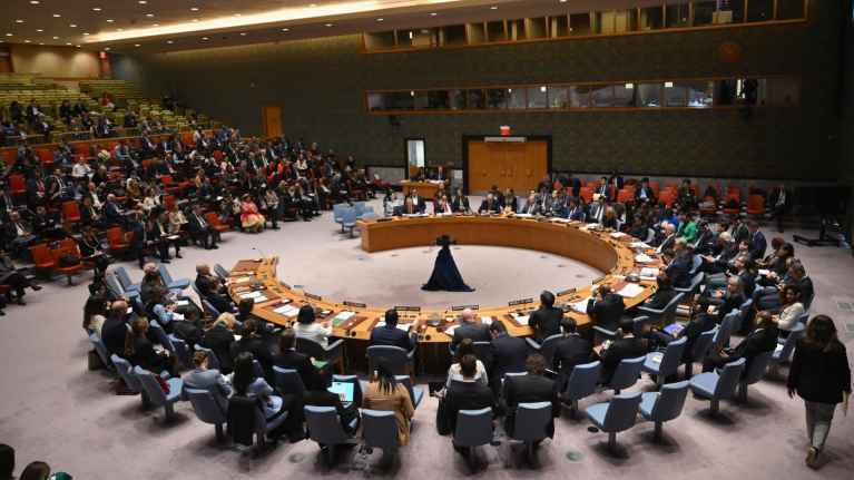 Turvallisuusneuvosto kokoontuu YK:n päämajassa puoliympyrän muotoisen kokouspöydän ympärillä.