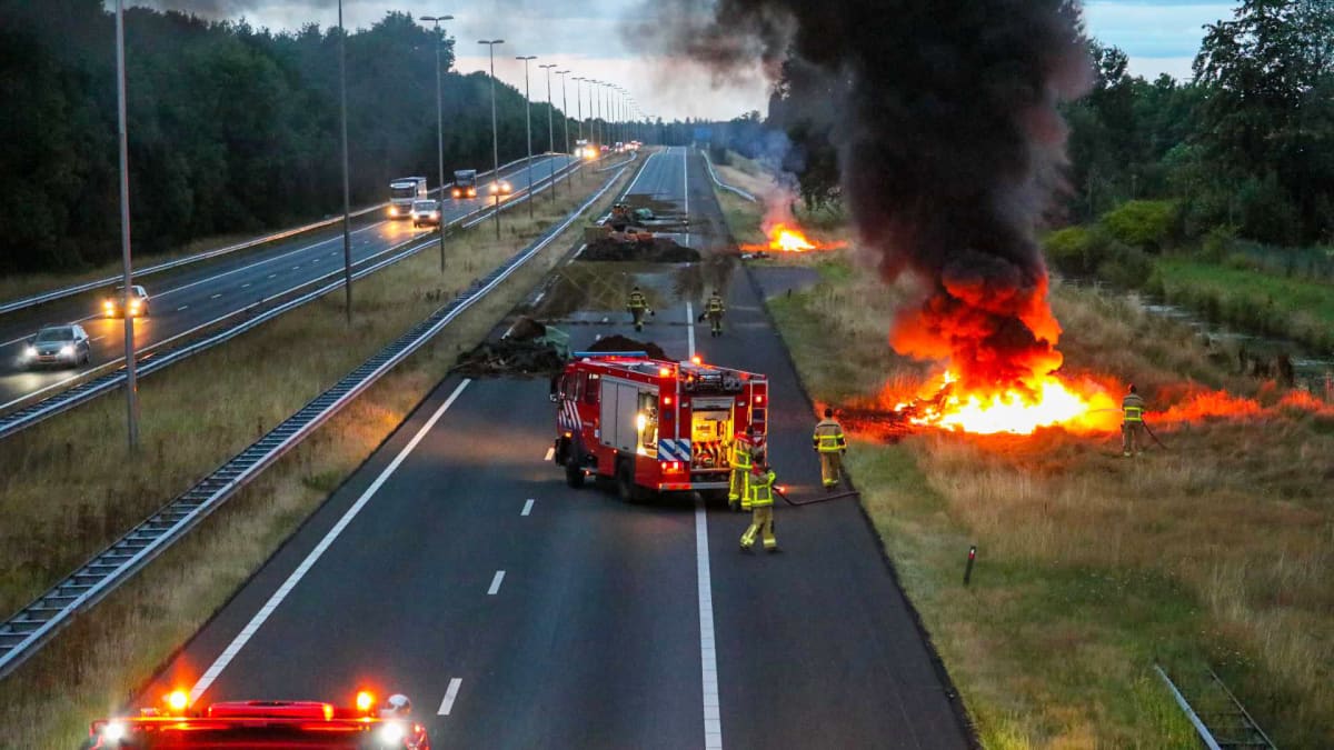 Palomiehet sammuttavat tulipaloa moottoritiellä.