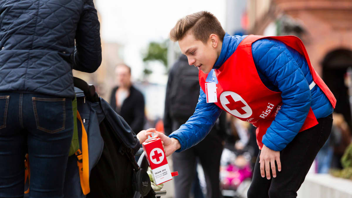 Nuori mies kerää kadulla rahaa lippaaseen Nälkäpäivä-keräyksen aikana.