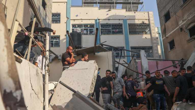 Palestiinalaisia on kokoontunut tutkimaan rakennuksen raunioita Israelin iskun jäljiltä Rafahin kaupungissa Gazan kaistalla.