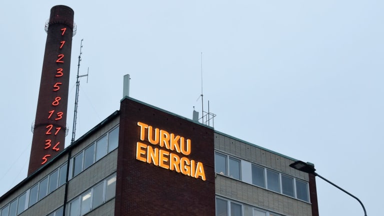 Turku Energian nimikyltti loistaa rakennuksen seinässä alkuillasta.