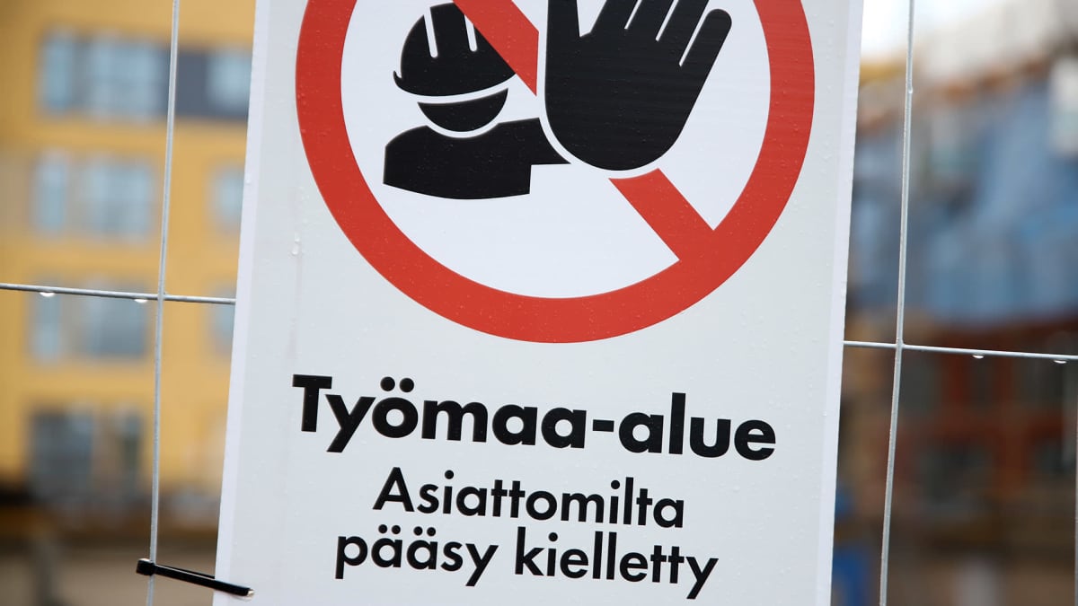 "Työmaa-alue"-kyltti rakennustyömaan aidassa. 