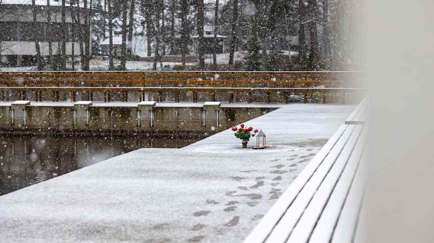 Muistomerkki, kynttilä ja kukkia.