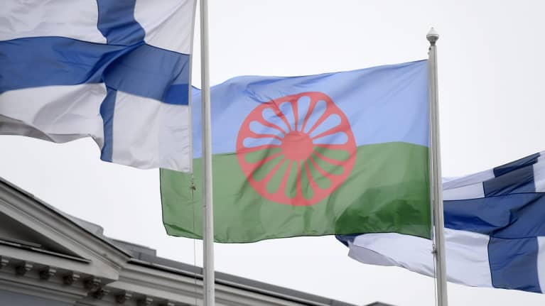 Romanien ja Suomen liput liehuvat salossa. Vuonna 1971 Lontoossa pidettiin ensimmäinen kansainvälinen romanikongressi ja hyväksyttiin romanien lippu. 