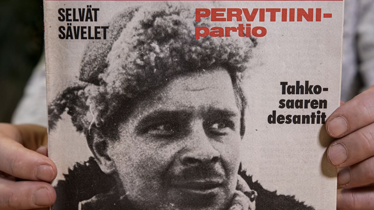 Mika Koivunen pitelee sormissaan Kansa taisteli -lehteä vuodelta 1978, jonka kannessa on hänen isänsä Aimo Koivusen kuva.