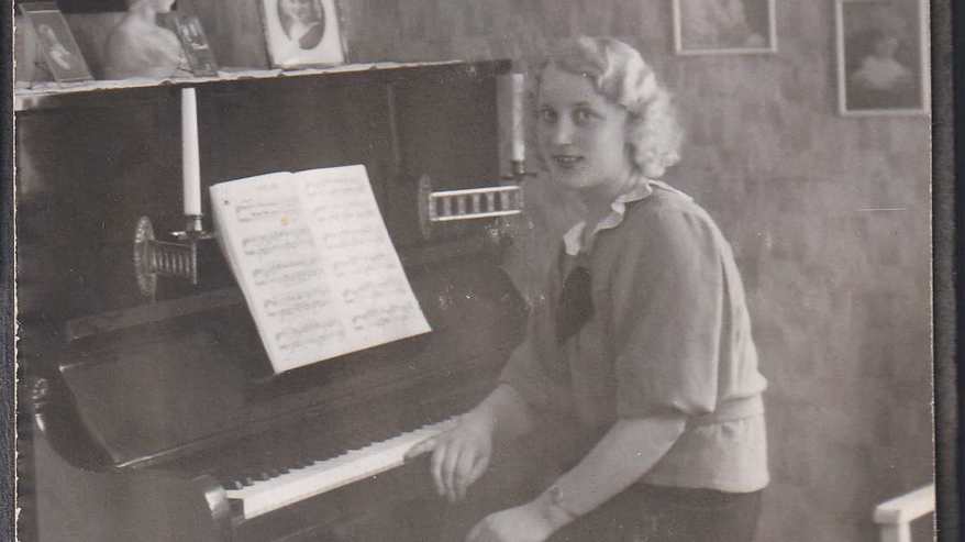Edit Lempiäinen (os. Holopainen) istuu pianon ääressä vanhassa valokuvassa.
