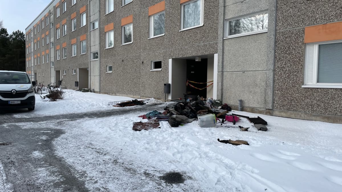 Hiiltyneitä tavaroita lojuu kerrostalon edessä