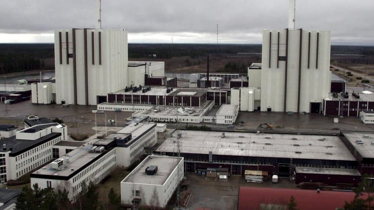 Aerial photo of two nuclear power reactors with a field in the background. 