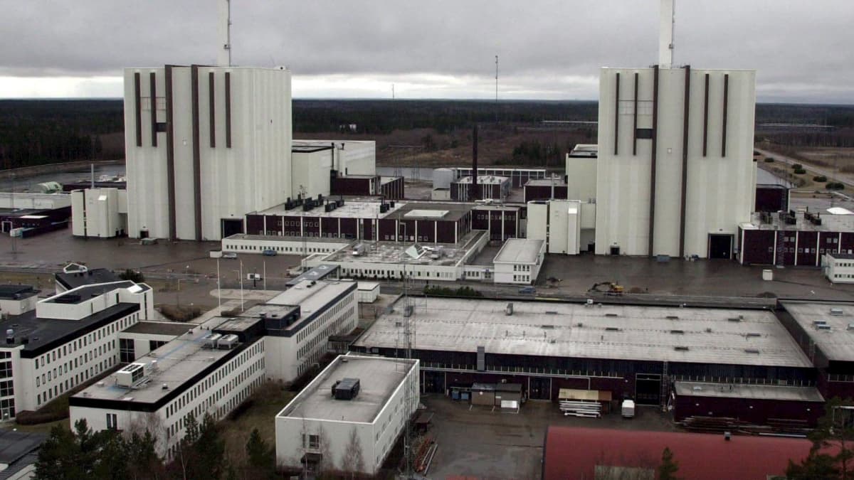 Kaksi valkoista ydinvoimalaa yläviistosta kuvattuna, takana näkyy syksyistä peltoa.
