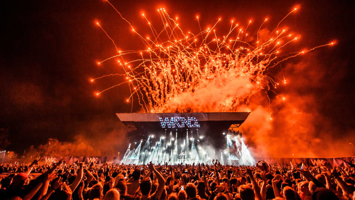 Red fireworks explode over the Weekend Festival stage at night in 2022.