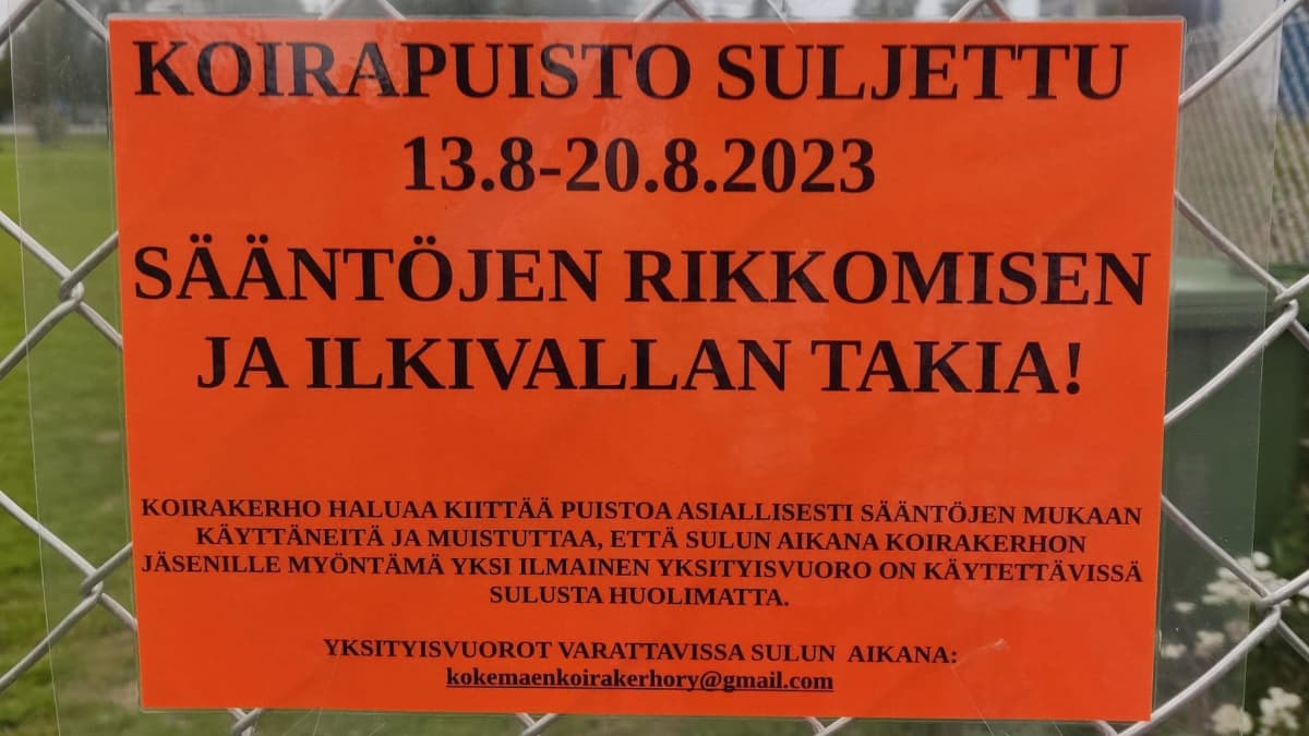 Punainen kyltti, jossa kerrotaan Kokemäen koirapuiston sulkemisesta sääntörikkomuksen takia.