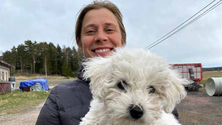 Mari Lindström med sin hund i famnen
