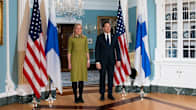 Foreign Minister Elina Valtonen stands next to US Secretary of State Marco Rubio. Both are smiling. On either side of them are Finnish and American flags.
