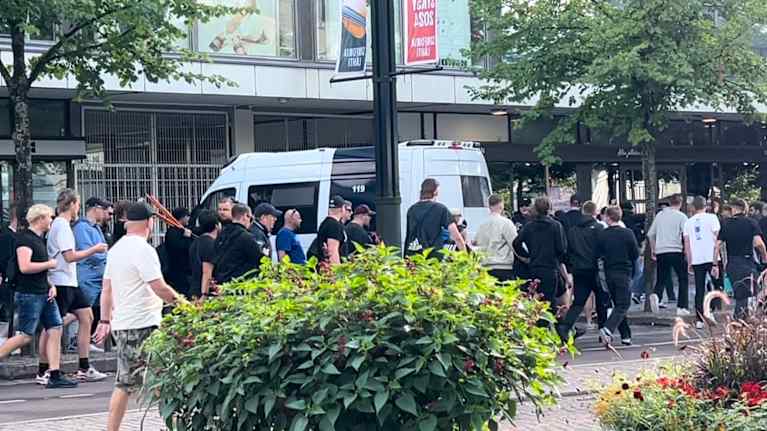 HJK supporters march in the center of Lahti. A police car is parked in the middle of the crowd.